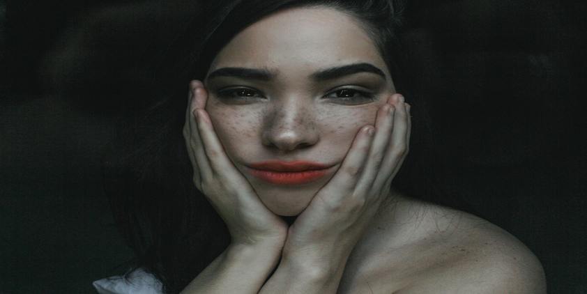 Unsplash freckled woman wearing red lipstick touching her face