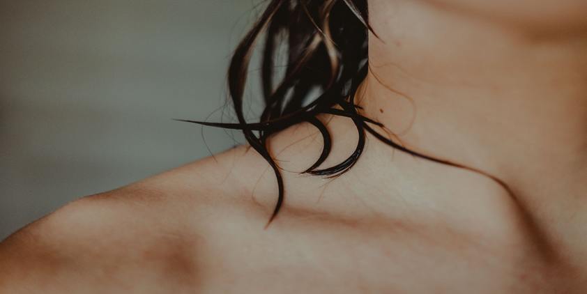 Unsplash. Closeup of woman's wet hair and collarbone
