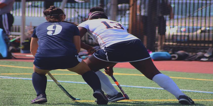 Unsplash. two girls fighting for ball playing field hockey