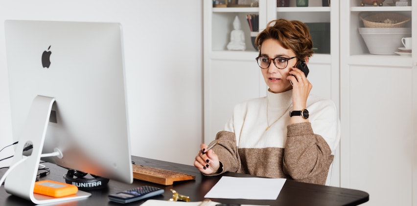 Woman talking on phone and working at computer