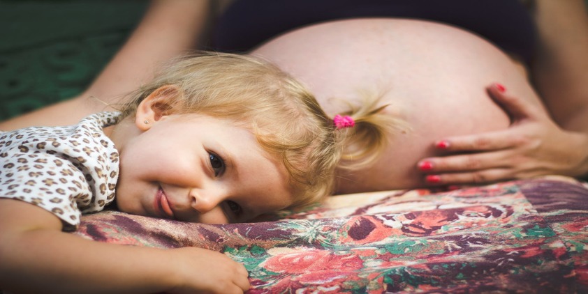 Pexels. Pregnant woman with toddler laying on her lap