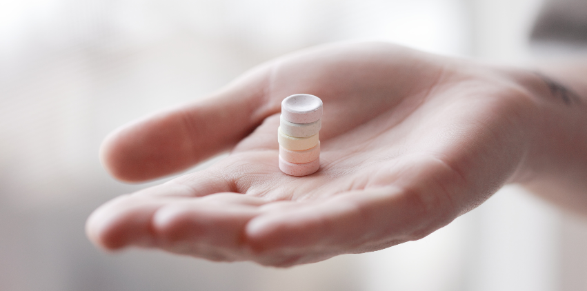 A woman holding a stack of vitamins