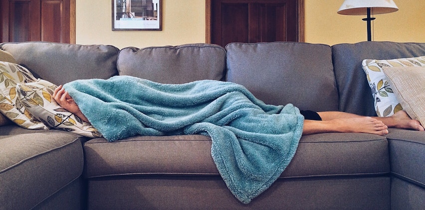 A woman sleeps poorly on a couch.
