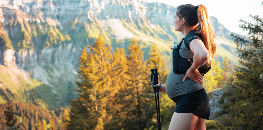 A pregnant woman hiking in the mountains