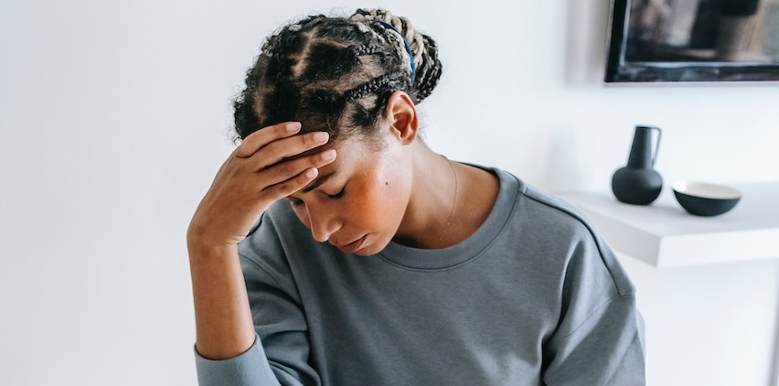 A woman holding her head due to a headache.