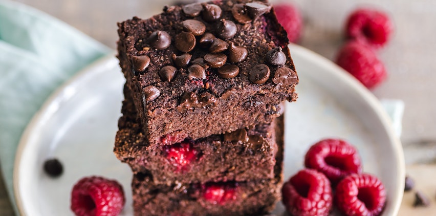 A stack of chocolate brownies with raspberries