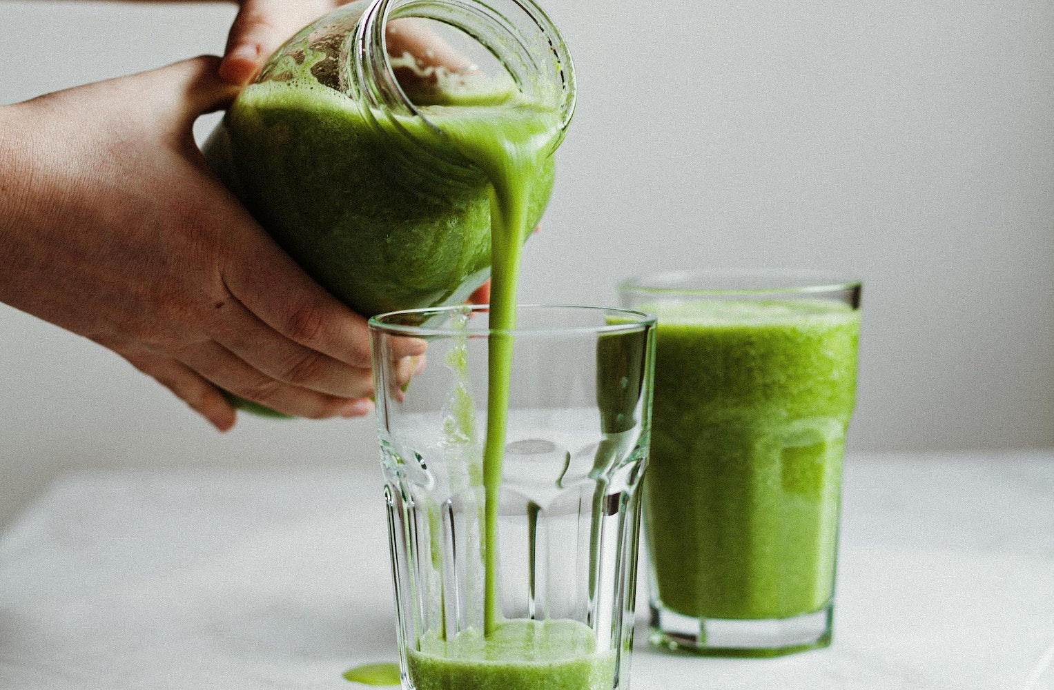 Pouring a green smoothie