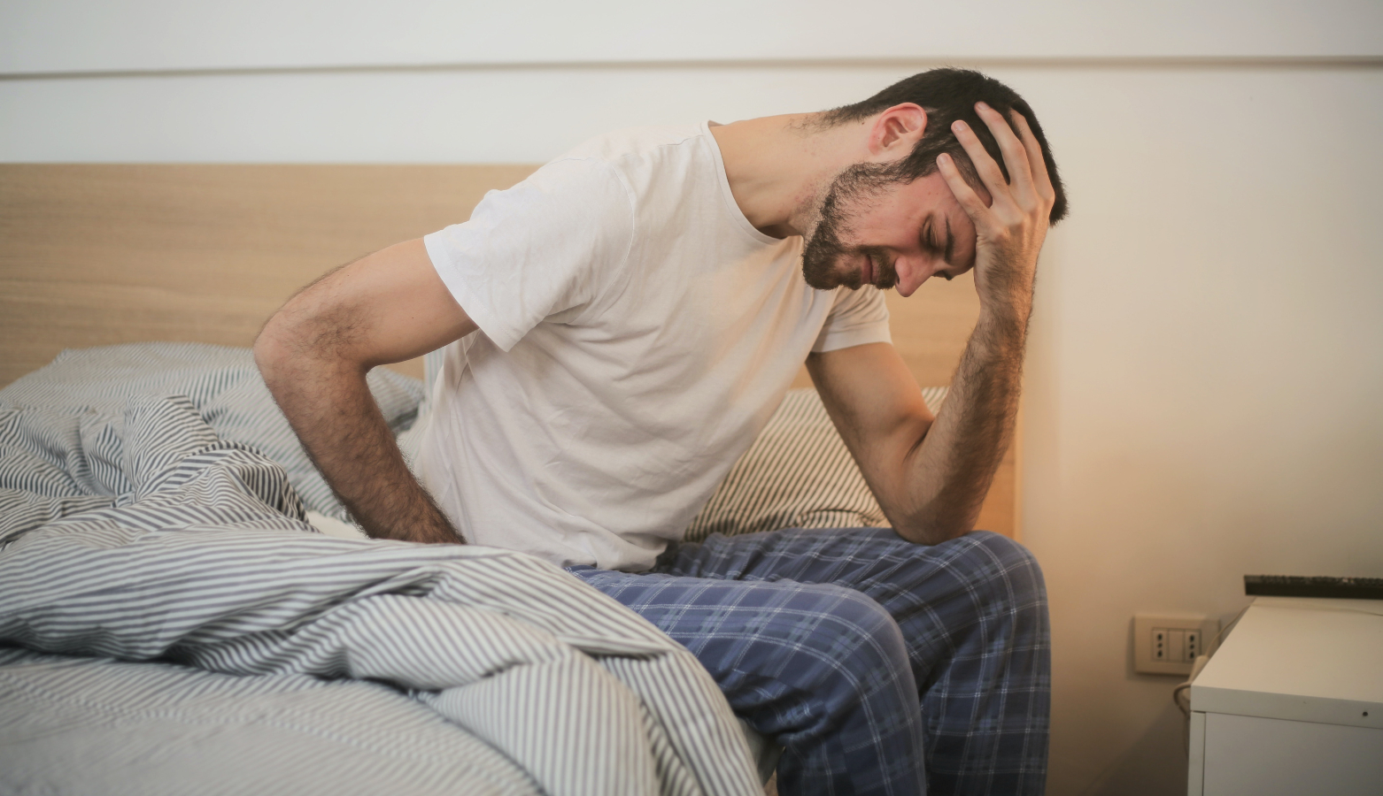 A man sitting in bed in pain