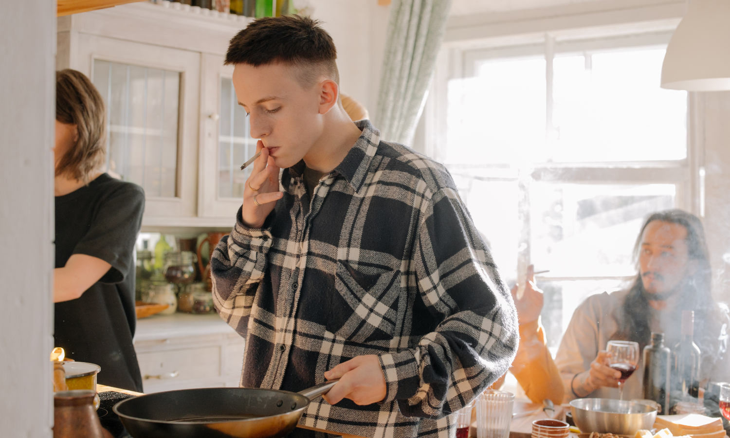 A man smoking in a kitchen
