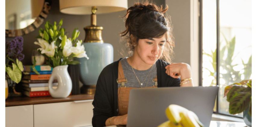 woman working at table with laptop freelance writing for beginners
