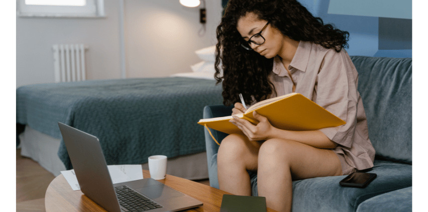 black woman working on couch looking at freelance writing websites
